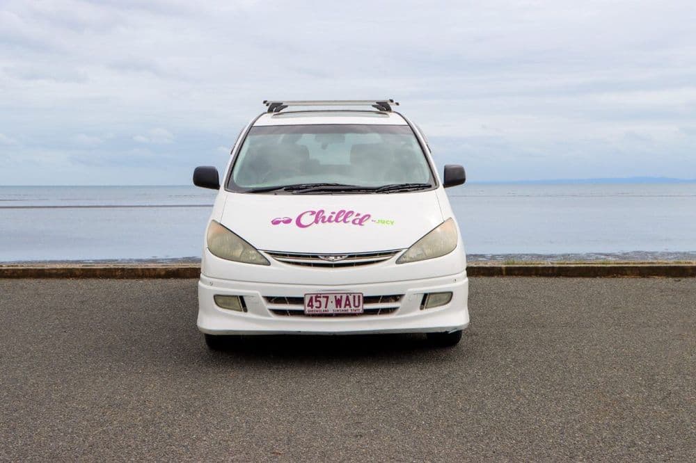 Head-on view of a white Chill'd-liveried Toyota people-mover, its front number plate reading 457 WAU, Queensland